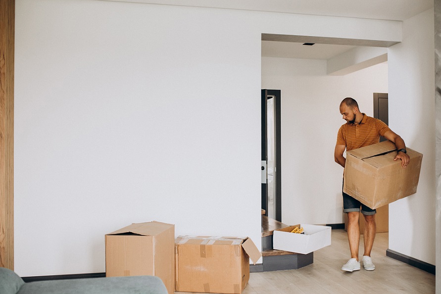 Office movers handling desks and monitors